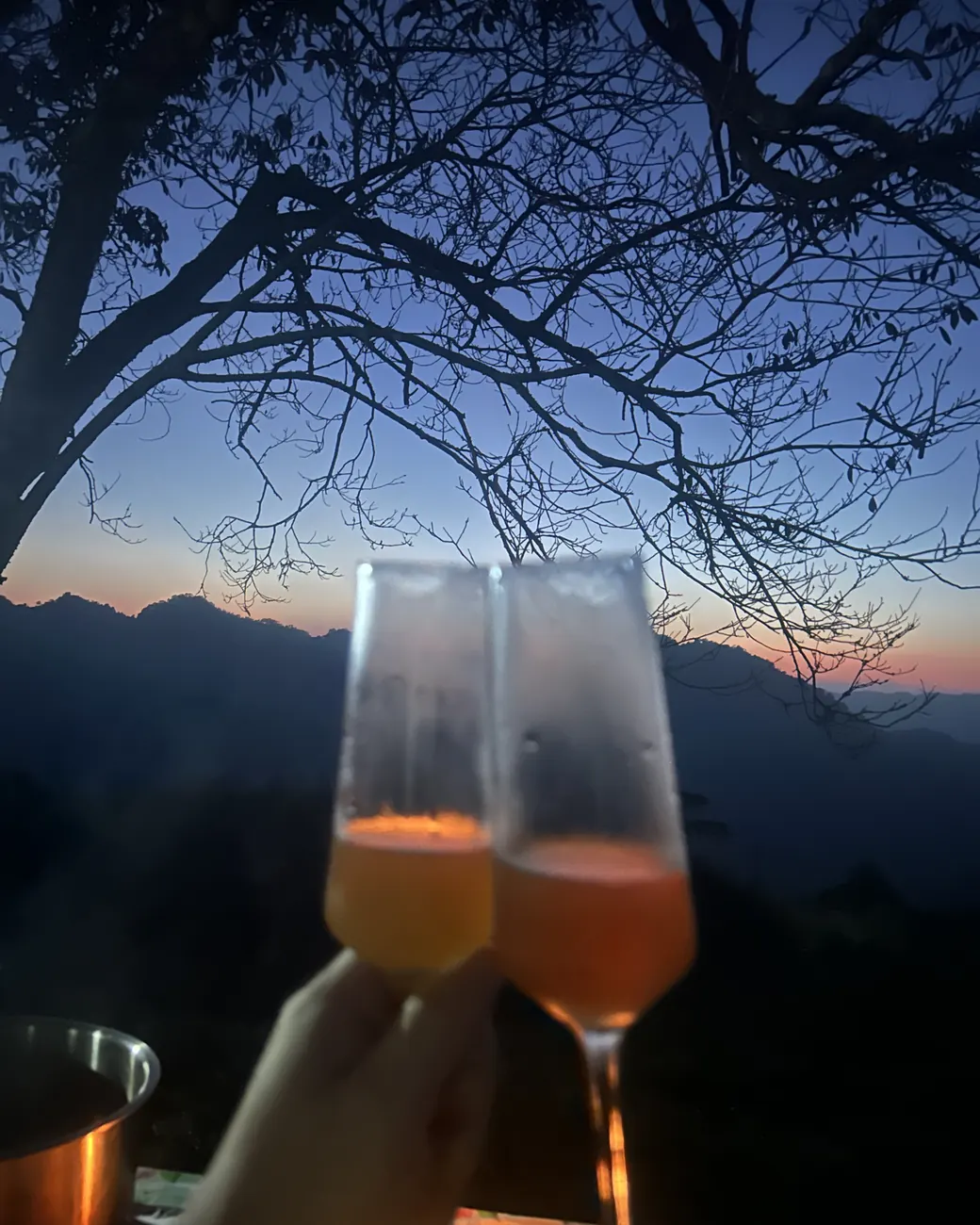 黃昏時在農舍前舉杯,山稜線後的天色正暗下來
