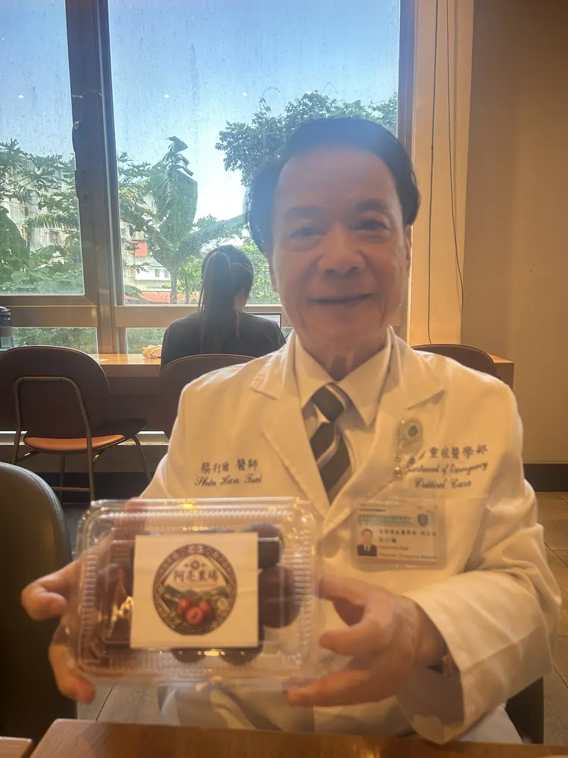 A friend who received red-flesh plums, smiling and holding a box with the Saluwan Farm label