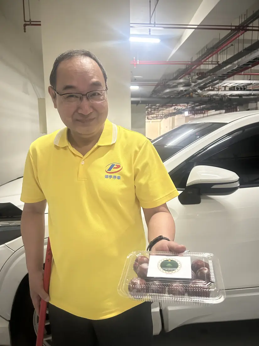 A friend who received red-flesh plums, smiling and holding a box with the Saluwan Farm label