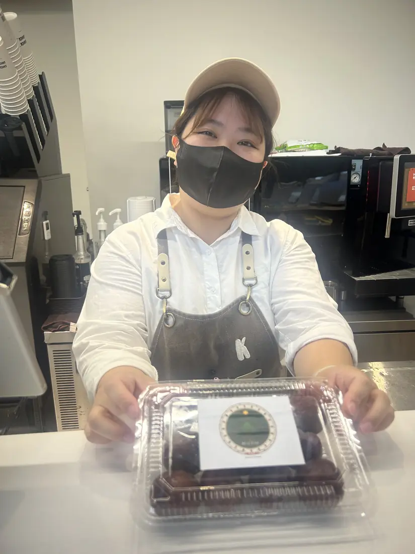 A friend who received red-flesh plums, smiling and holding a box with the Saluwan Farm label